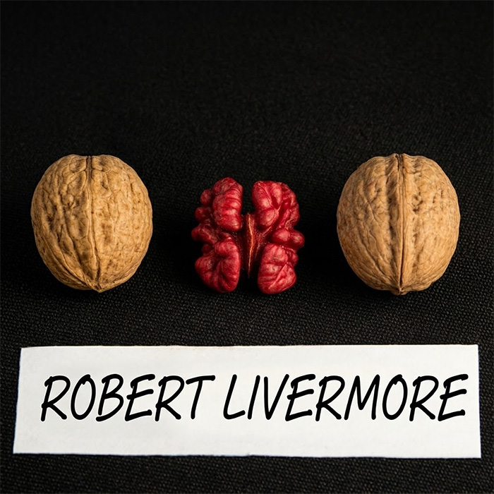 two Robert Livermore walnuts in the shell beside a cracked kernel showing its natural red colour